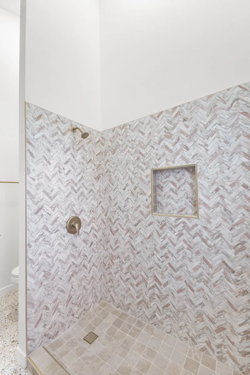 Marble herringbone shower. Herringbone carried around an inside corner without breaking the pattern.