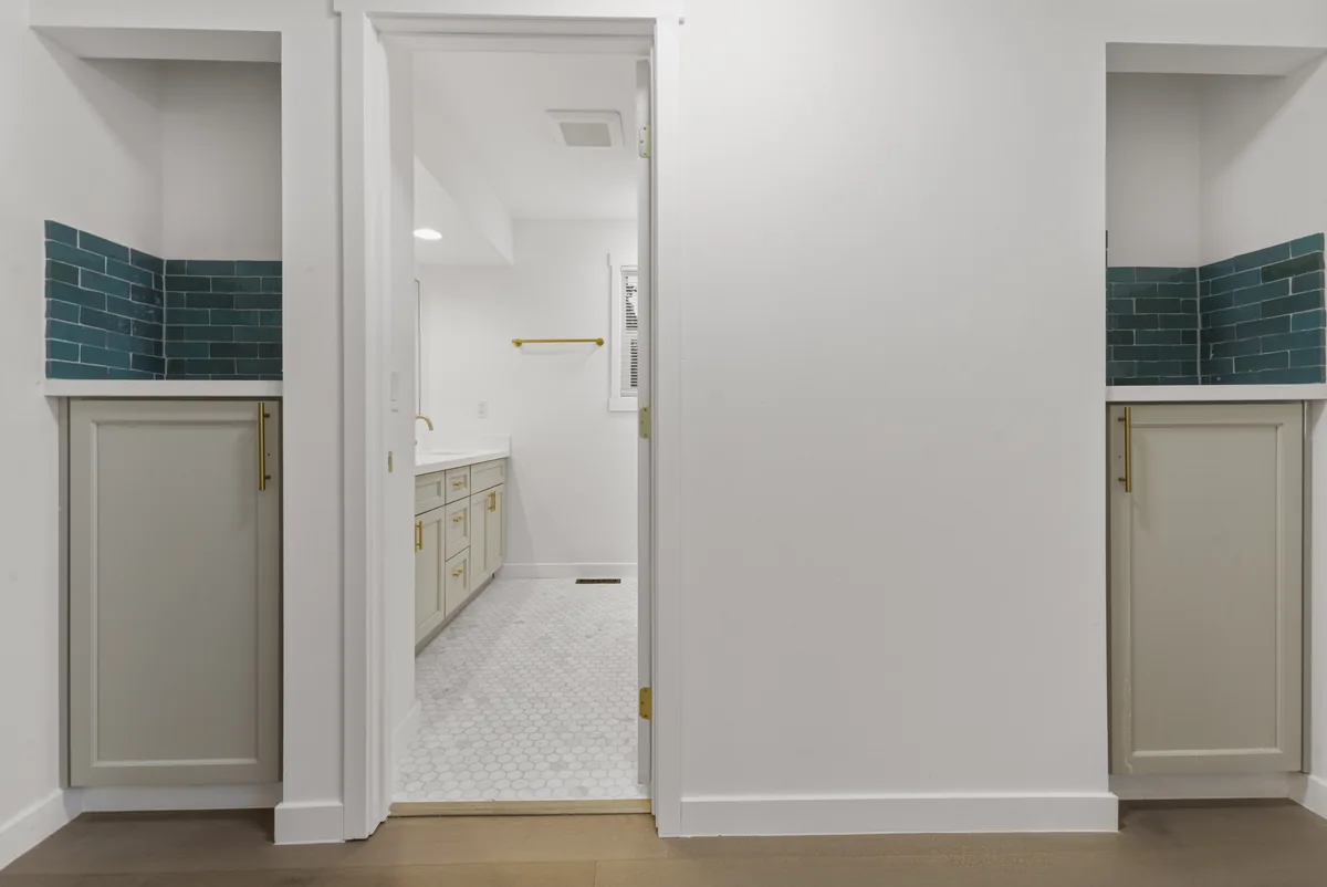 Teal tile bath. Glazed teal set in a stack bond, carried through both vanity alcoves.