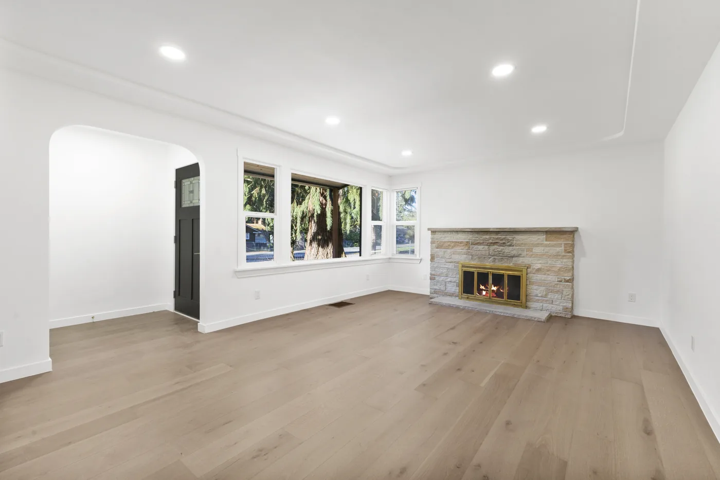 White oak through the living space. Plank run continuous from the entry through to the fireplace with no thresholds.
